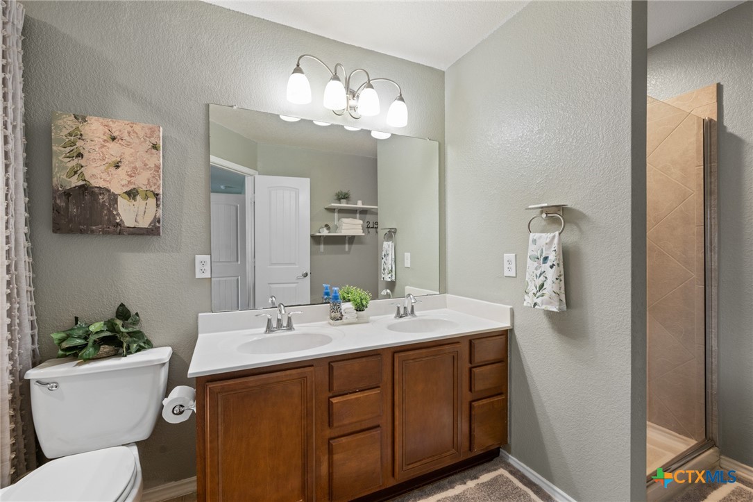 9142 Sage Loop Court Temple, TX 76502 - Photo 18 of 27 a bathroom with a toilet a sink and mirror
