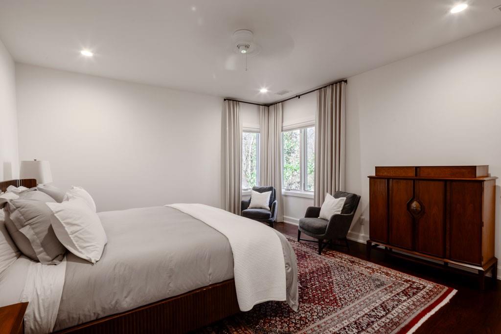 4036 Conway Valley Road Northwest Atlanta, GA 30327 - Photo 16 of 26 a bedroom with a bed a dresser and a large window