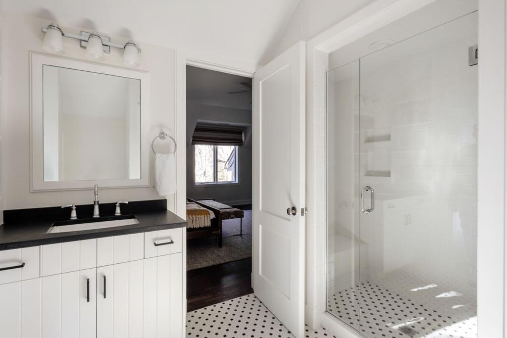 4036 Conway Valley Road Northwest Atlanta, GA 30327 - Photo 18 of 26 a bathroom with a sink a mirror and a shower