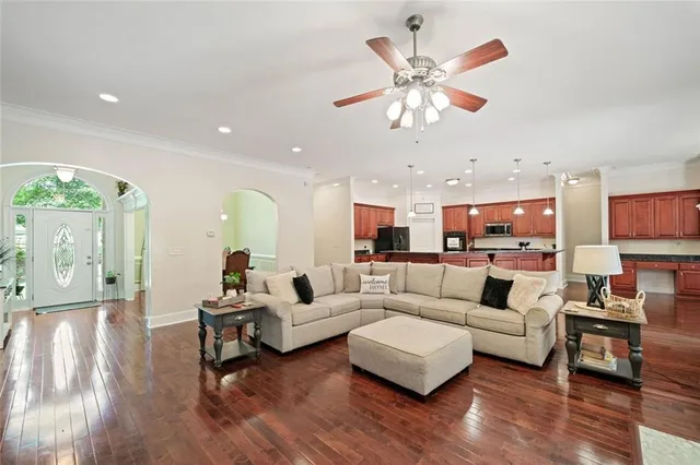 a living room with furniture kitchen view and a large window