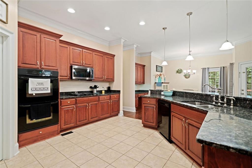 106 Shalea Lane Ball Ground, GA 30107 - Photo 18 of 52 a large kitchen with stainless steel appliances granite countertop a stove a sink dishwasher a refrigerator and a microwave oven