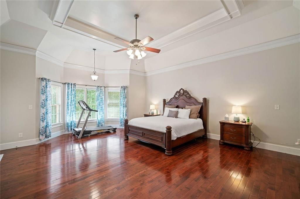 106 Shalea Lane Ball Ground, GA 30107 - Photo 24 of 52 a spacious bedroom with a bed chandelier and a large window