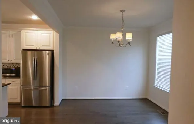 a view of a refrigerator in kitchen and wooden floor