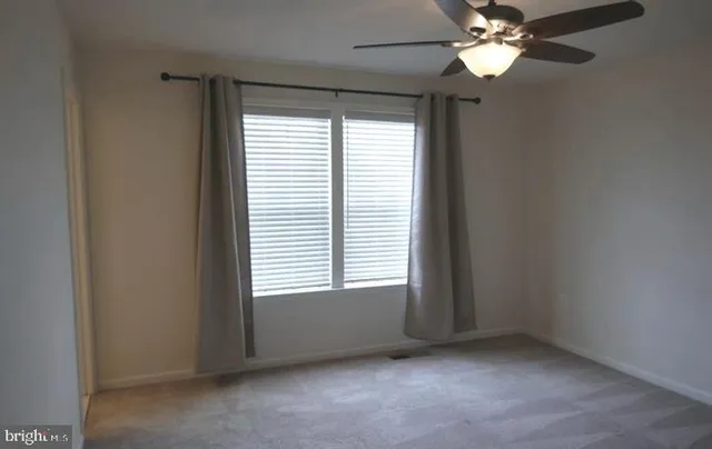 an empty room with a chandelier fan