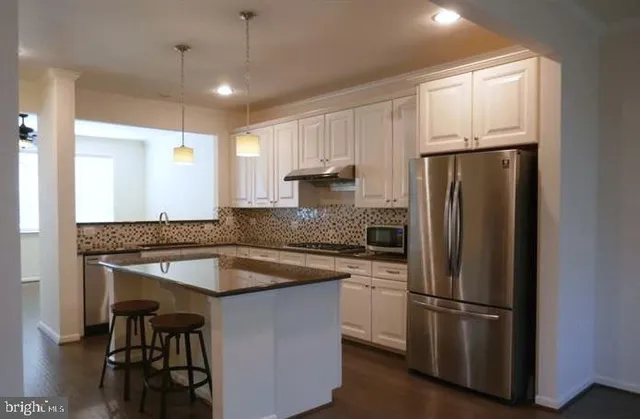 a kitchen with a refrigerator a sink and cabinets