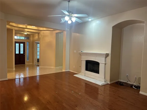 a view of a livingroom with a fireplace wooden floor and chandelier