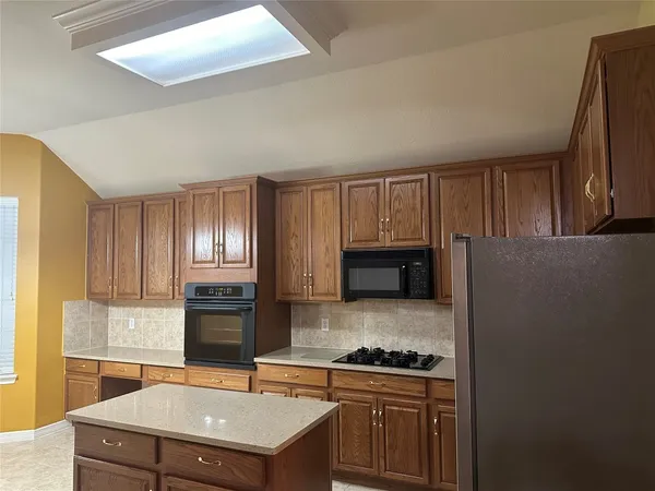 a kitchen with a stove a sink and a refrigerator