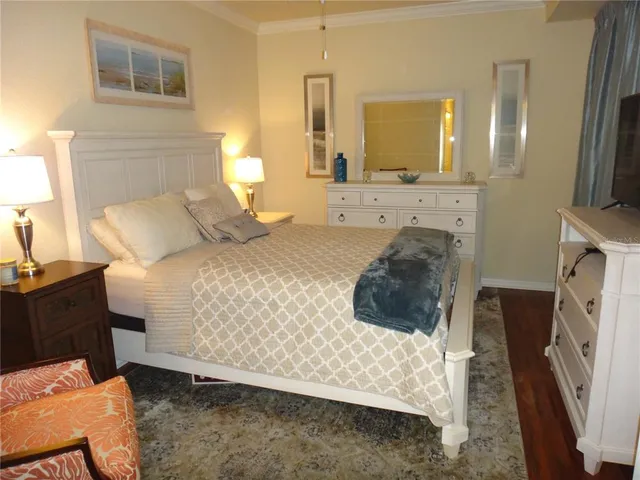 a bedroom with a bed a mirror and dresser