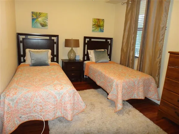a bedroom with two beds and painting on the wall