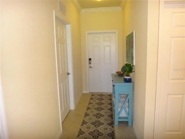 a view of a hallway with wooden floor and a bathroom