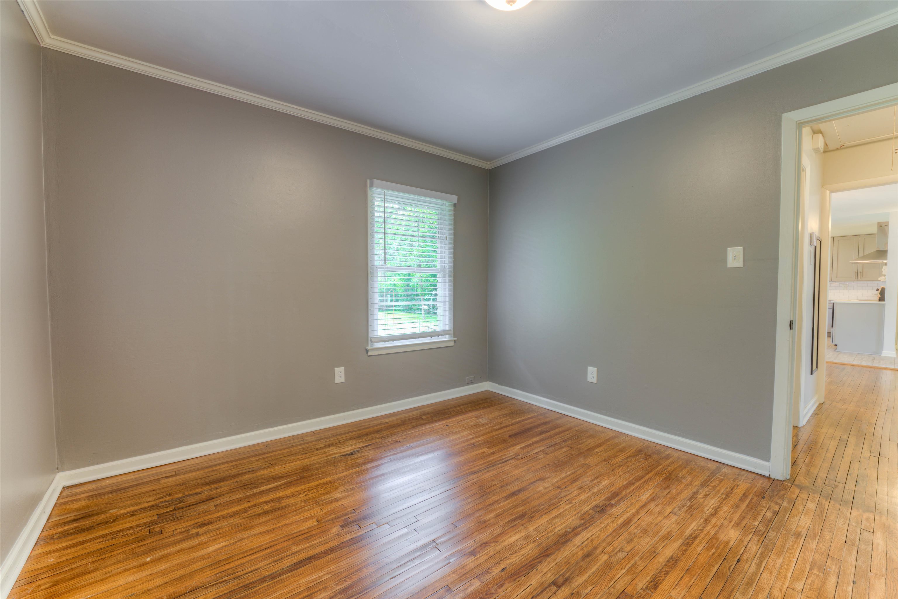 4427 Quince Road Memphis, TN 38117 - Photo 14 of 26 a view of an empty room with wooden floor and a window