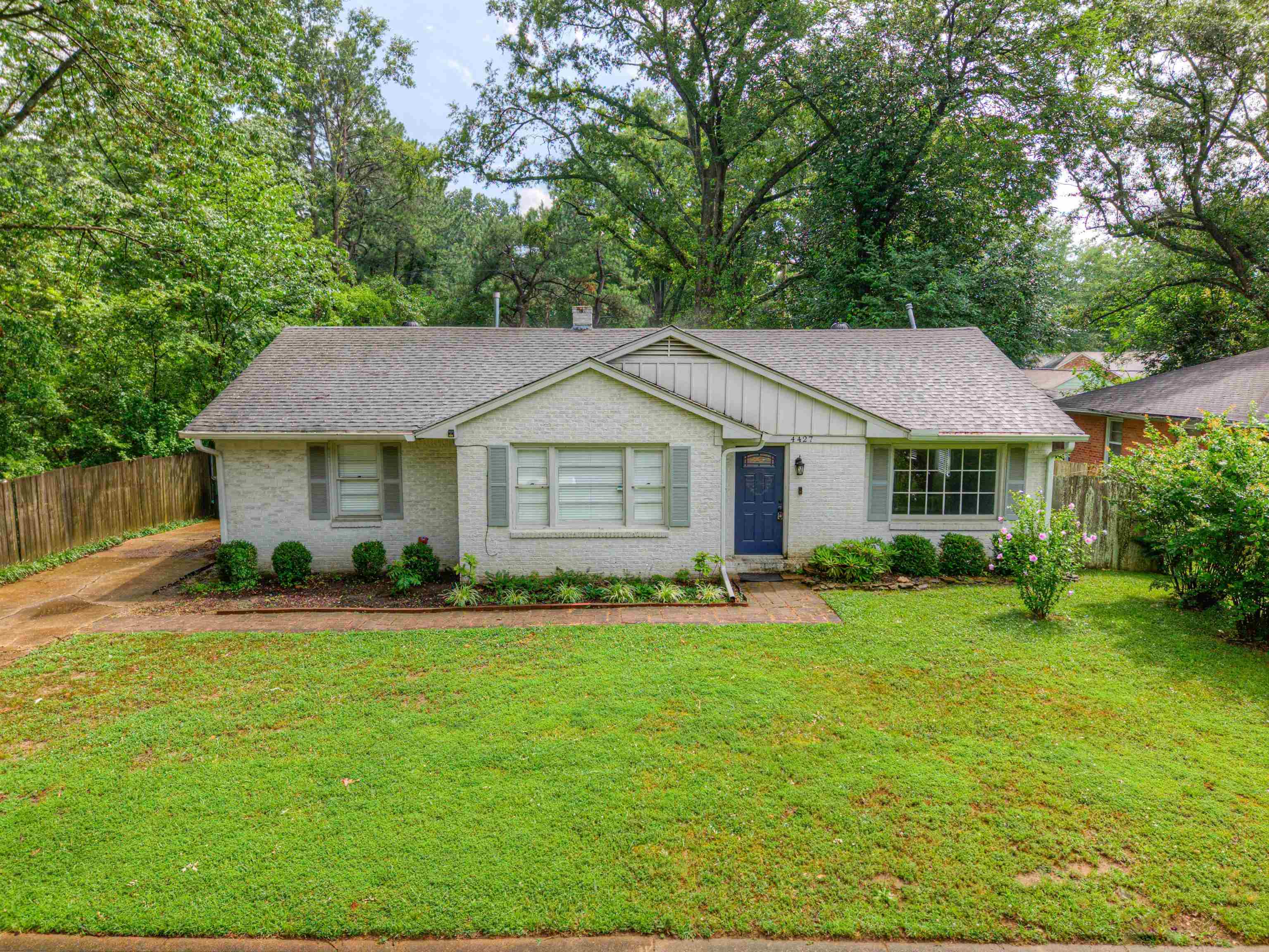 4427 Quince Road Memphis, TN 38117 - Photo 2 of 26 a front view of a house with a yard and trees