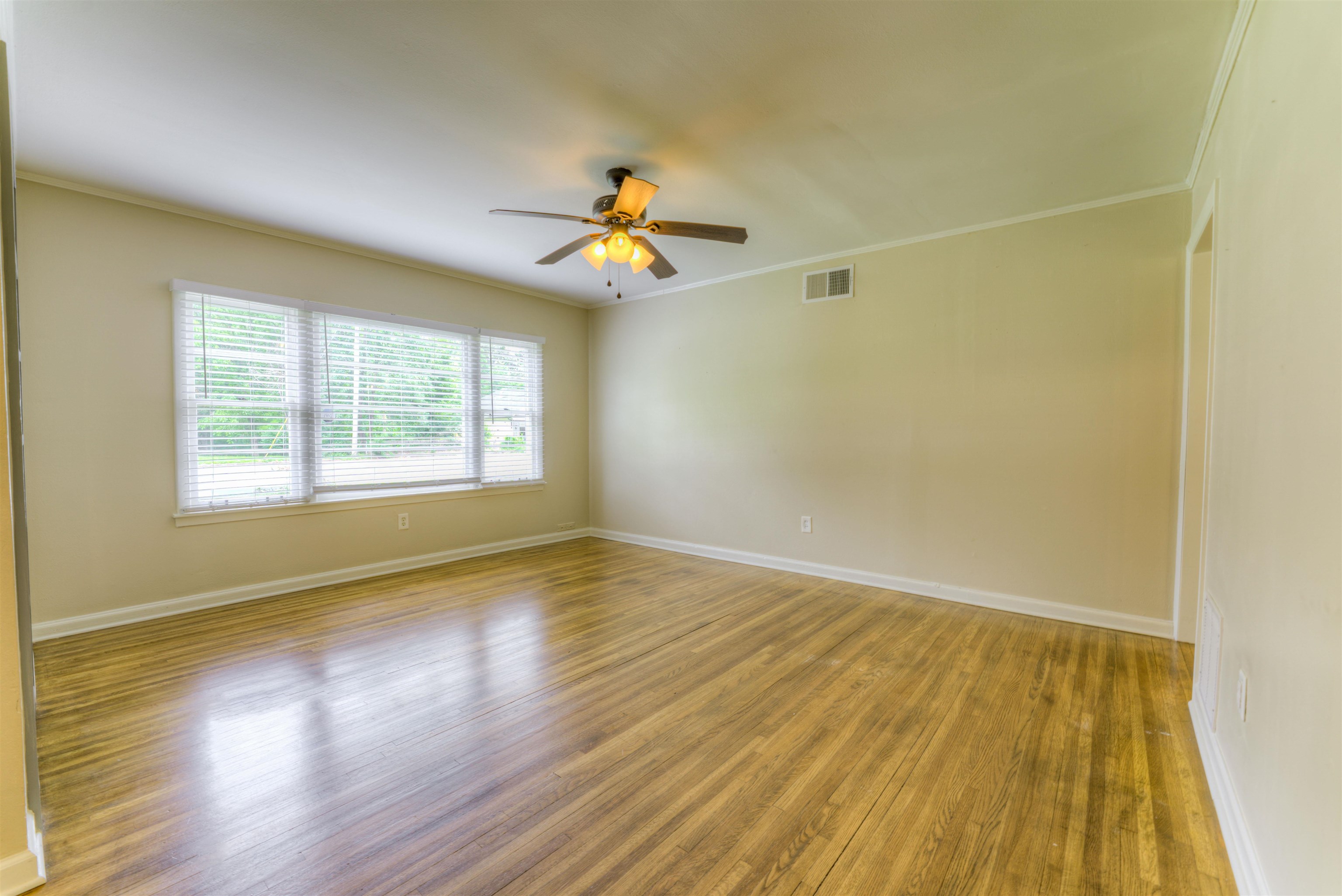 4427 Quince Road Memphis, TN 38117 - Photo 7 of 26 a view of an empty room with wooden floor and a window