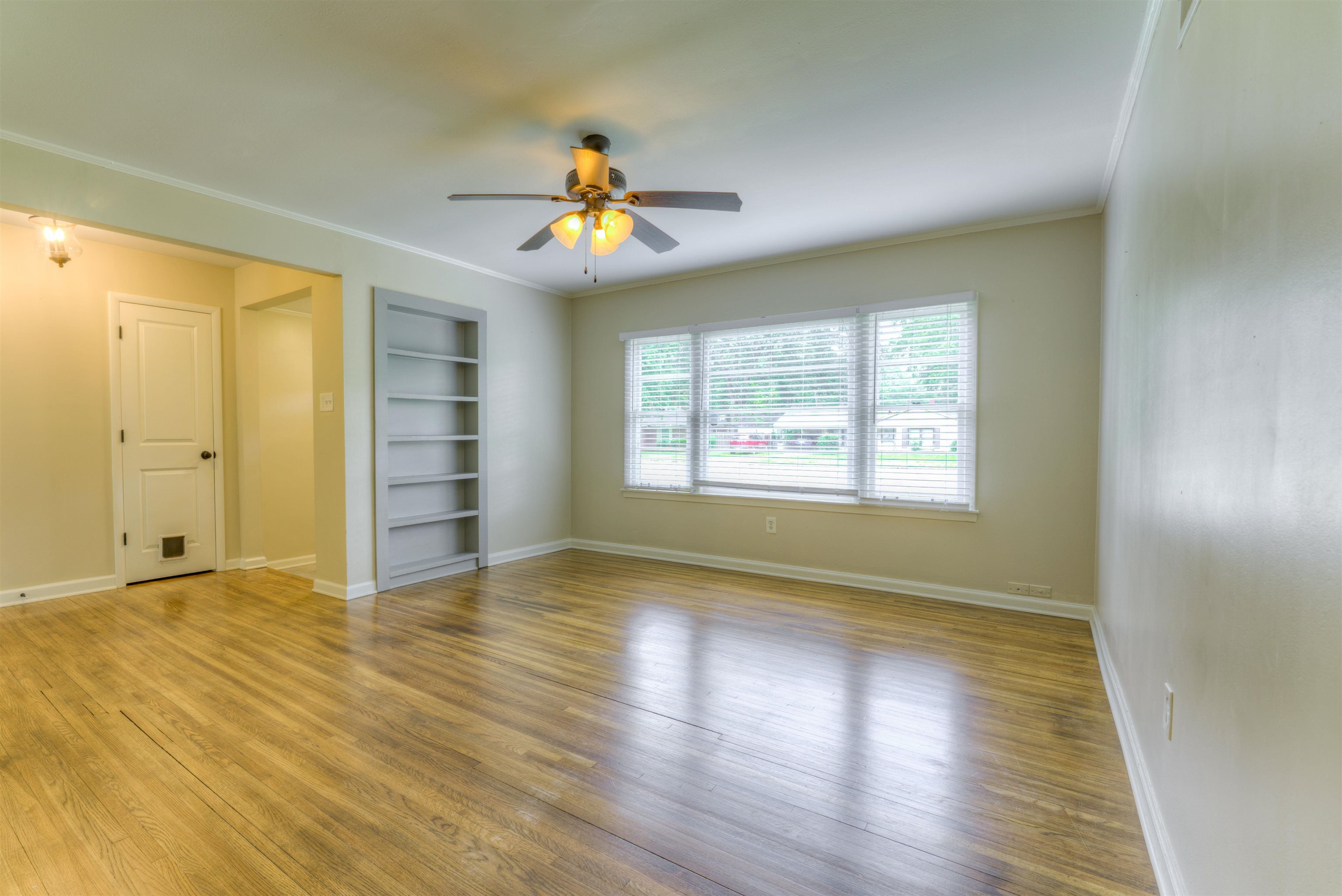 4427 Quince Road Memphis, TN 38117 - Photo 8 of 26 a view of an empty room with a window and wooden floor