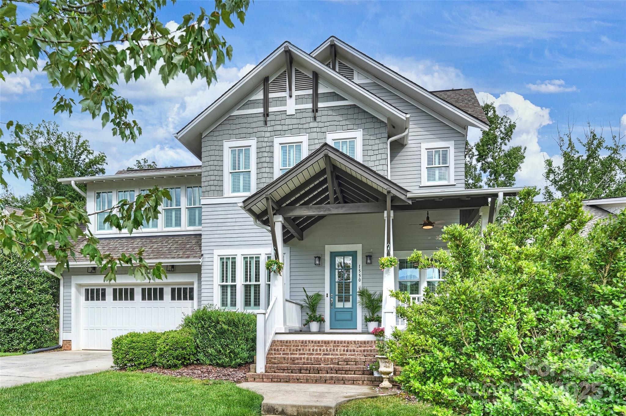 a front view of a house with a yard and potted plants