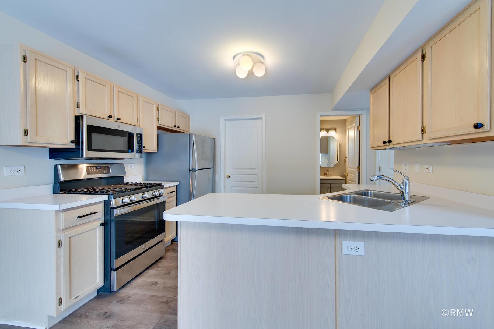 1223 Summersweet Lane Bartlett, IL 60103 - Photo 7 of 22 a kitchen with stainless steel appliances granite countertop a sink stove and microwave