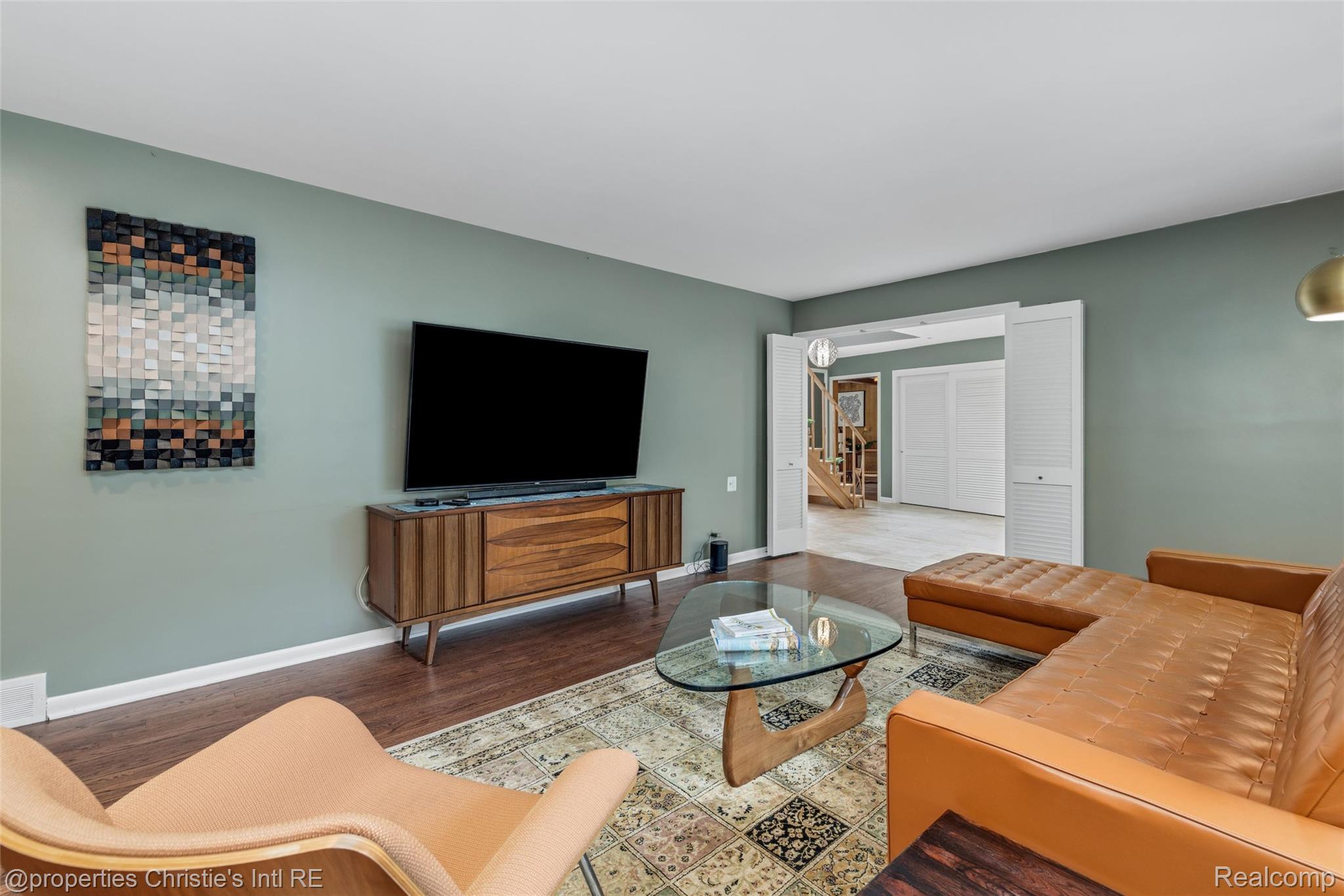 2771 West Seven Mile Road Detroit, MI 48221 - Photo 23 of 57 Spacious living area featuring wood-finish flooring, light green walls, and white baseboards