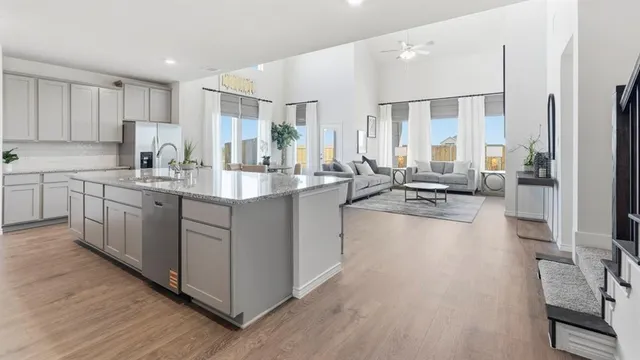 a large white kitchen with a large window and stainless steel appliances