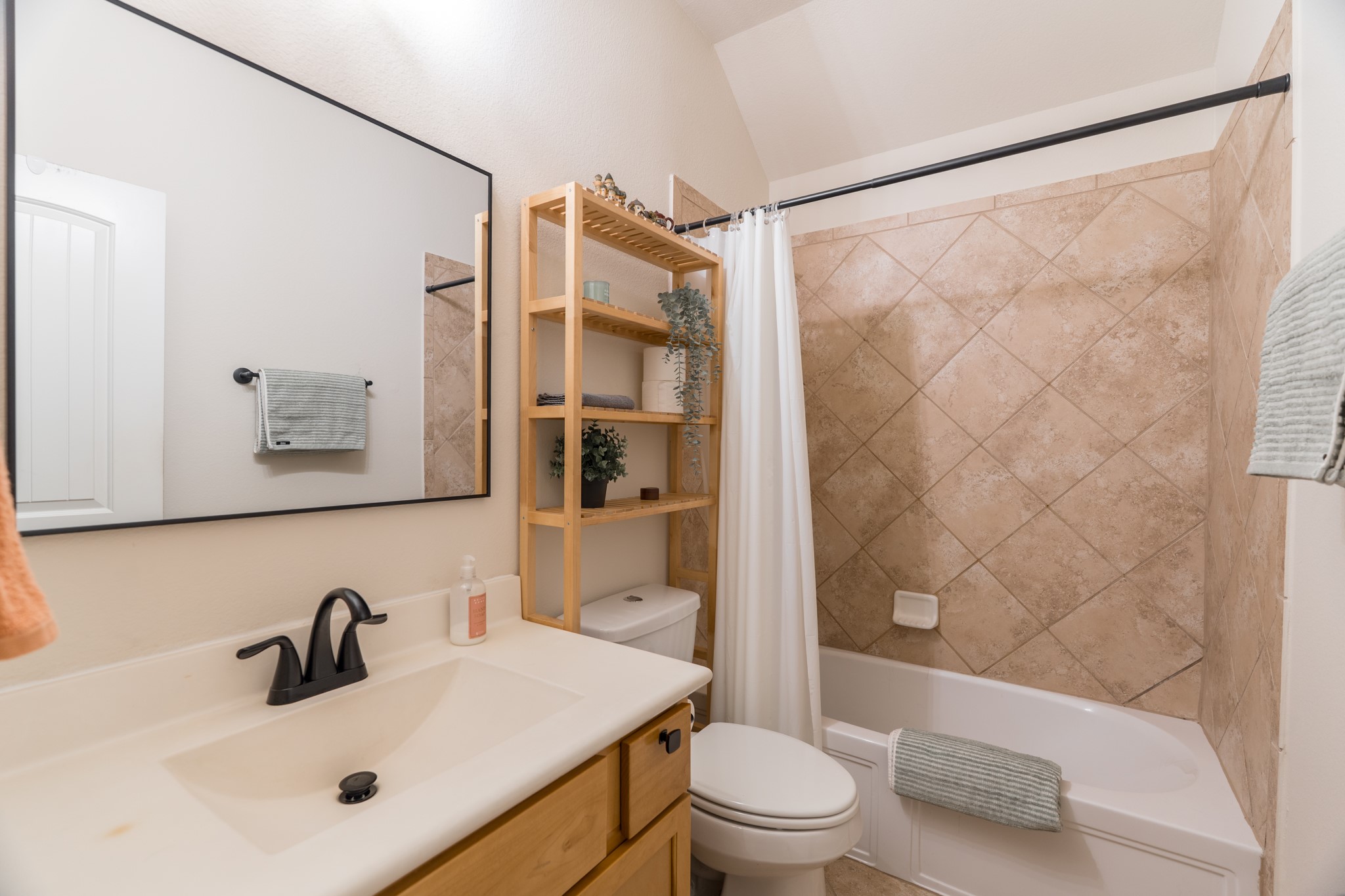 79 West Jagged Ridge Circle Spring, TX 77389 - Photo 36 of 50 This full secondary bathroom features a tiled shower-tub combination, a clean vanity with modern matte black fixtures, and a large mirror. Conveniently located near the secondary bedrooms, it's a practical and stylish space for family or guests to enjoy.