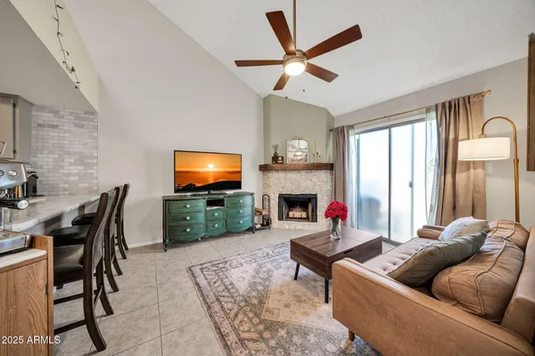 a living room with furniture a fireplace and a flat screen tv