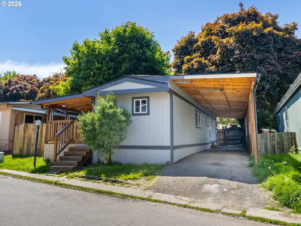 a front view of a house with a garden and plants