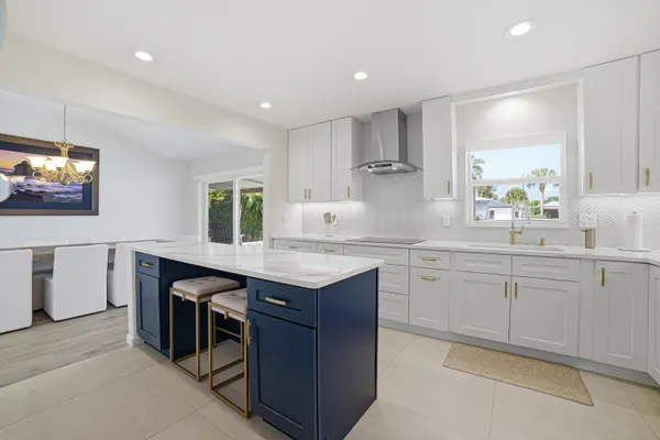 a kitchen with granite countertop a sink and white cabinets