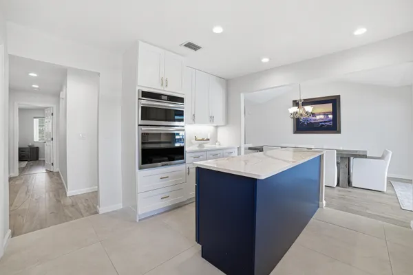 a kitchen with stainless steel appliances kitchen island hardwood floor sink and stove