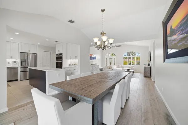 a kitchen with stainless steel appliances granite countertop a kitchen island a stove a table and chairs