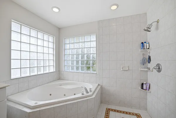 a bathroom with a tub a window and a shower