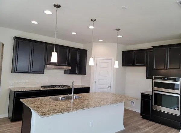 a kitchen with stainless steel appliances granite countertop a sink a stove and a microwave