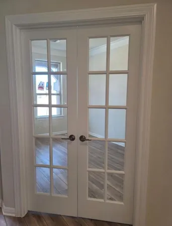 a living room with hard wood floors and a kitchen