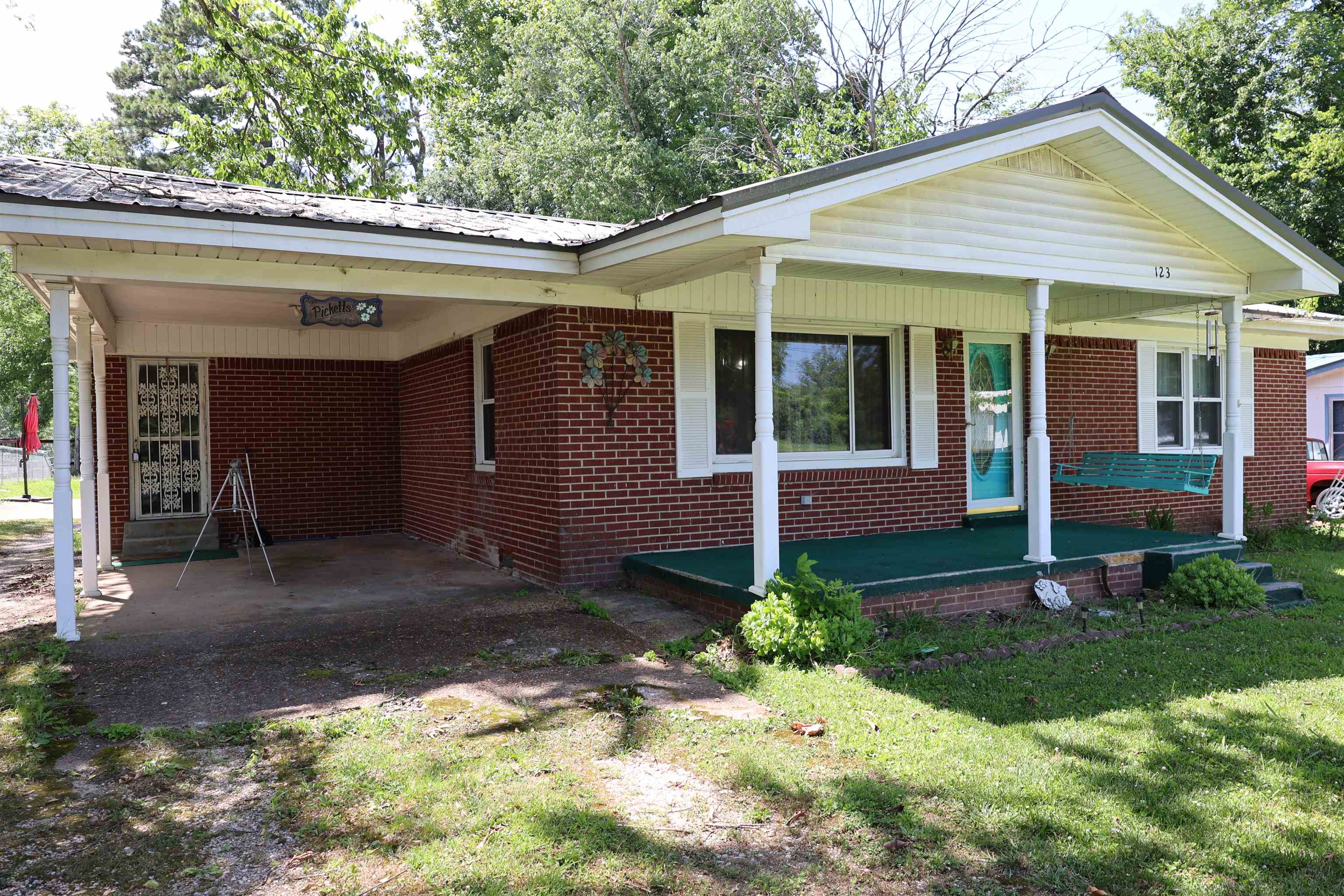 123 North Magnolia Street Adamsville, TN 38310 - Photo 2 of 25 a view of a house with a small yard plants and large tree