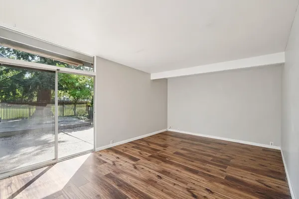 a view of empty room with wooden floor