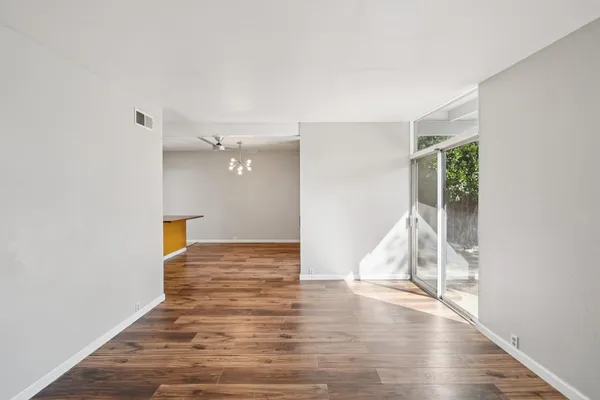a view of an empty room with wooden floor