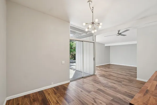 a view of a hallway with wooden floor and a chandelier