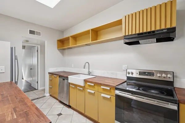 a kitchen with stainless steel appliances wooden floor and a refrigerator