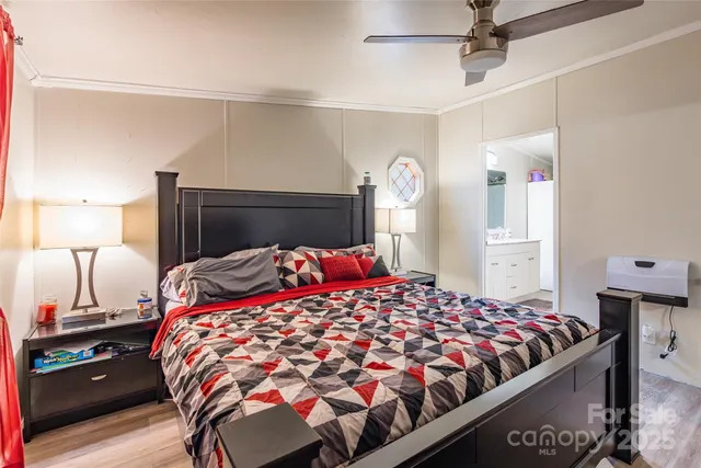 a bedroom with a large bed and a lamp on dresser