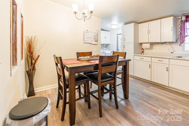 a kitchen with a table chairs sink and cabinets
