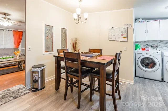 a view of a dining room with furniture a chandelier and wooden floor