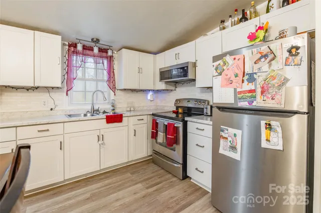 a kitchen with stainless steel appliances a sink and a refrigerator