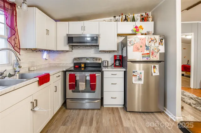 a kitchen with stainless steel appliances granite countertop a refrigerator and wooden cabinets