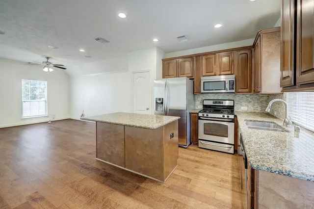 a kitchen with kitchen island granite countertop a stove cabinets and sink