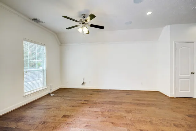 an empty room with windows and fan