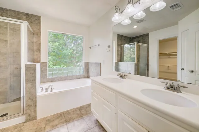 a bathroom with a tub sink and mirror