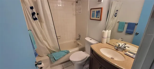 a white toilet sitting next to a bathroom sink and a mirror