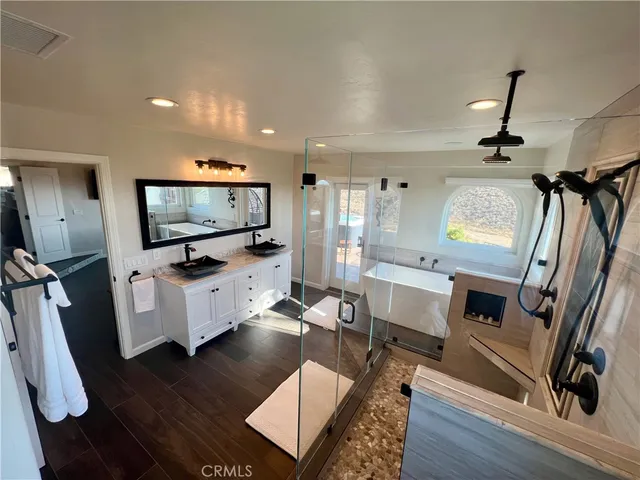 a bedroom with two beds chandelier and a window