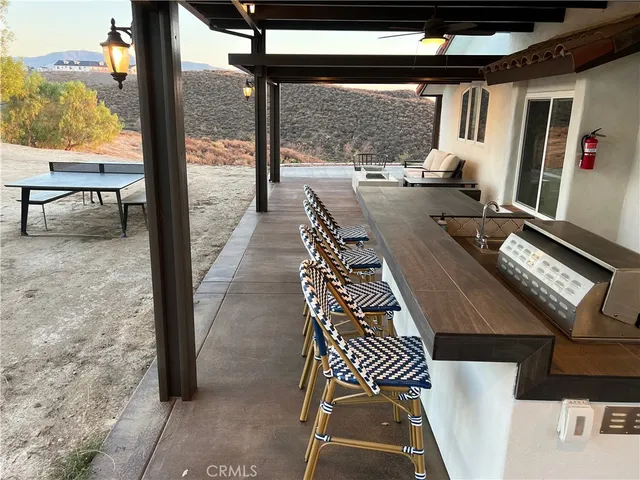 a backyard of a house with barbeque oven table and chairs