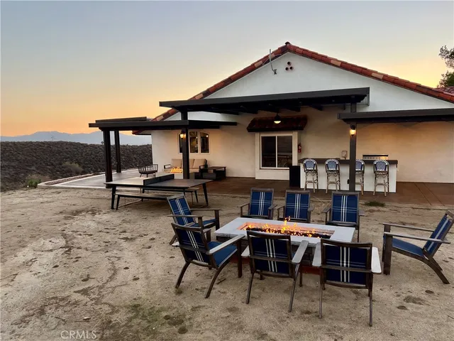 a backyard of a house with table and chairs