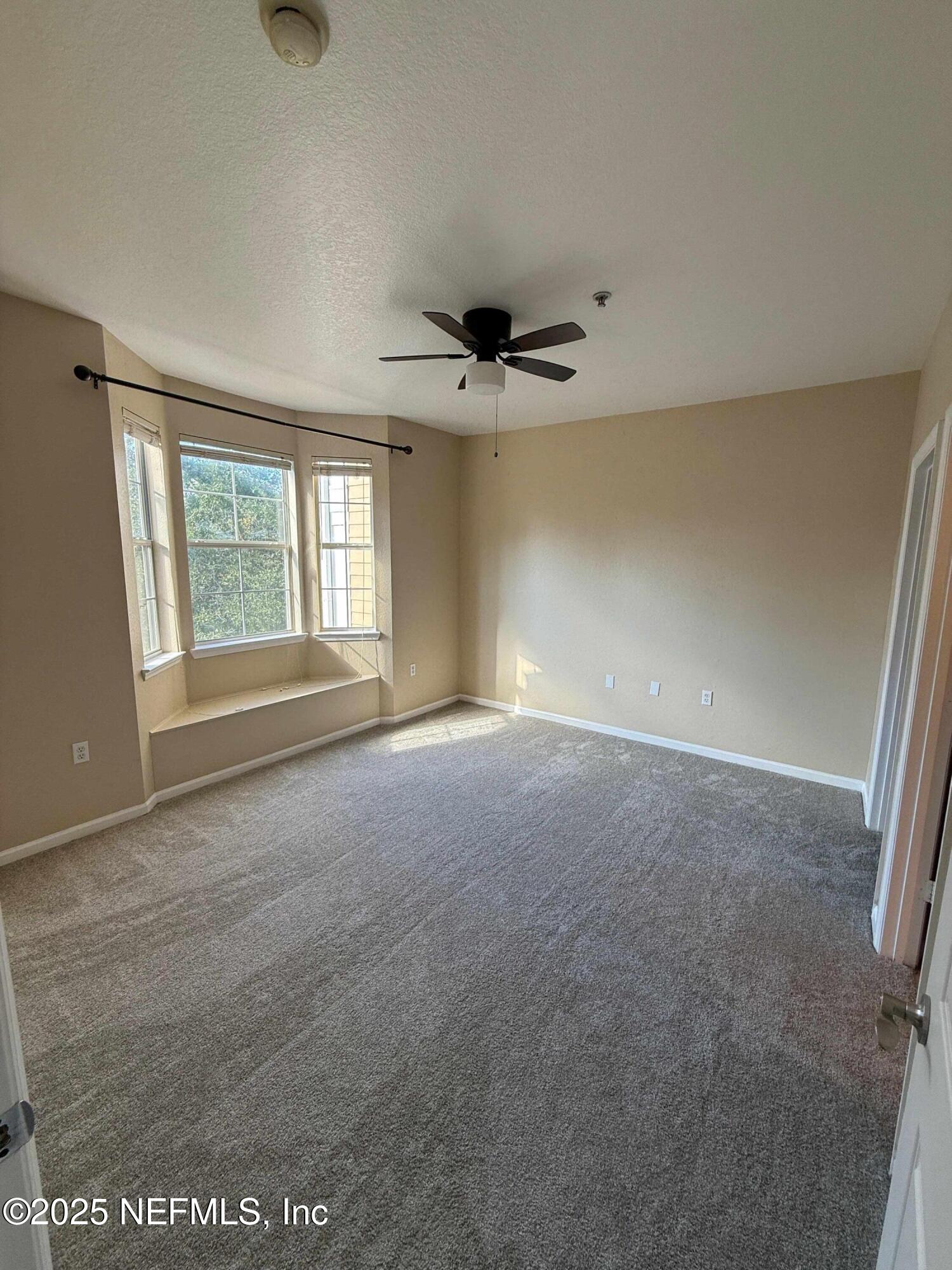 8550 Touchton Road, Unit 1633 Jacksonville, FL 32216 - Photo 14 of 21 an empty room with windows and chandelier fan