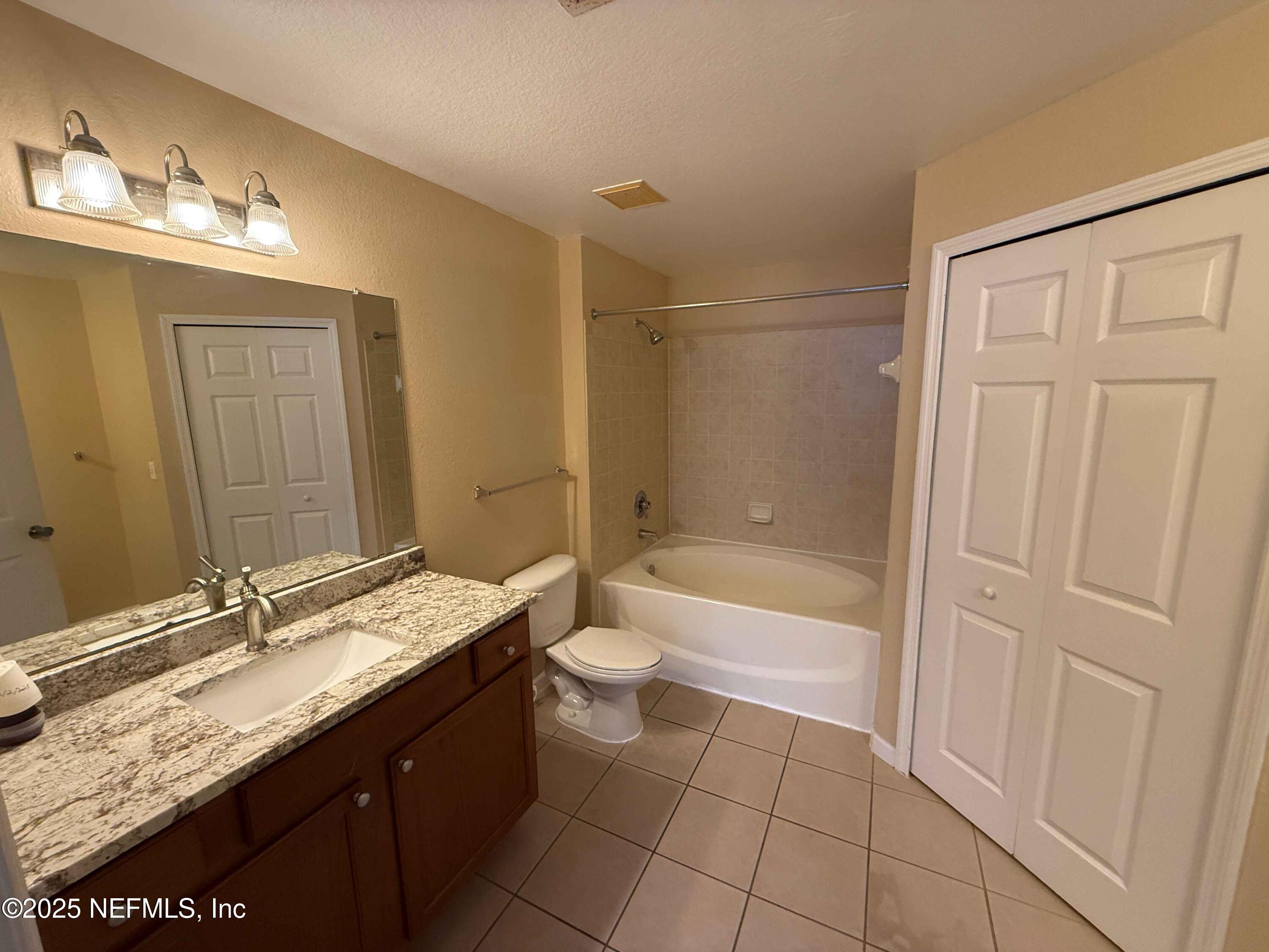 8550 Touchton Road, Unit 1633 Jacksonville, FL 32216 - Photo 18 of 21 a bathroom with a granite countertop sink toilet and shower